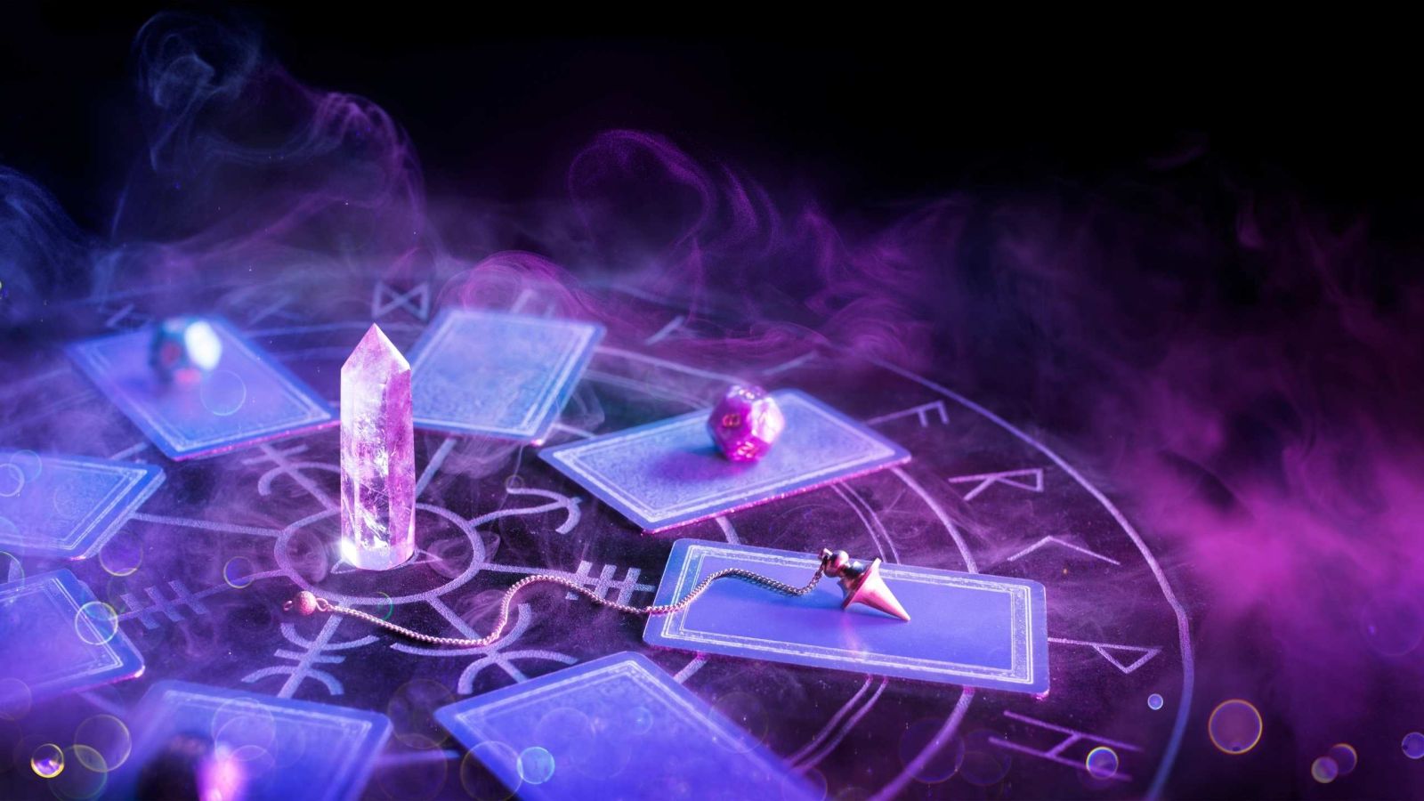Photo of purple tarot cards with crystals on dark table and purple mist